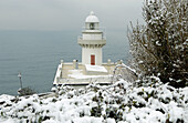 Snow in the coast. Igeldo lighthouse. San Sebastian, Donostia. Euskadi. Spain.