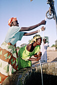 Women from the wolof tribe taking water out of the village well. Cayor. Senegal