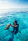 Underwater fisherman and his catch, a lagoon grouper. Manihi atoll. Tuamotu Archipielago. French Polynesia
