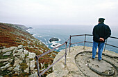 Man overlooking the sea. Granite rocks. Pointe du Raz. Cape Frehel. Finistere. Brittany. France