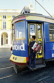 Young street musician travelling complimentary. Local Tramway Electrico . Lisbon. Portugal