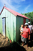 Family in local hut (walls and roof are made of corrugated iron). Rodrigues Island. Mauritius