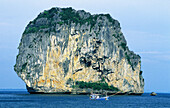 Small fishing boats by a huge rock. Phang Nga Bay. Phuket Island. Thailand