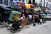 Commercial street and rickshaws. Macau, China