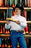Leddy s Boots & Saddles shop vendor showing an ostrich leather boot. Stockyards, Fort Worth. Texas, USA