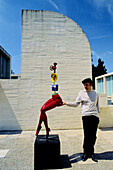Man petting irrevently a sculpture in Joan Miró Foundation. Barcelona. Spain