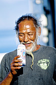 Man drinking local beer Hinano in a can. Tahiti island in the Windward islands. Society archipelago. French Polynesia