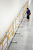 Student looking at notice board. Escuela Universitaria Politecnica, UPV (Universidad del Pais Vasco), Campus de Gipuzkoa. San Sebastián, Euskadi, Spain