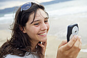 16 year old teengirl using cell phone at beach