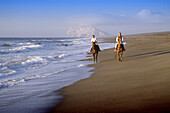 Horse riding at Sotogrande beach with the Rock of Gibraltar in background. Cádiz province. Spain