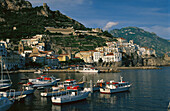 View of town with fishing harbor. Amalfi. Campania. Italy