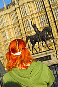 Teenage tourist looks at the Statue of Richard I outside Westminster Hall, London. England, UK