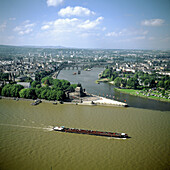 Barge passing the Deutsches Eck confluence of the Rhine and Mosel rivers, Koblenz. Germany