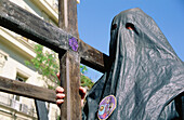 Nazareno (penitent) of Fratenidad de los Estudiantes with cross at the Holy Week. Sevilla. Andalusia, Spain