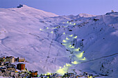 Snowy January landscape in Solynieve skiing resort by Pico Veleta, Sierra Nevada: the central run is illuminated only in Saturday evenings. Granada province, Andalusia, Spain