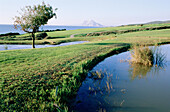 Golf course of Alcaidesa housing development, Mediterranean coast and Rock of Gibraltar in background. Cádiz province, Andalusia, Spain