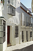 Alley and white-washed walls in the monumental quarter of Arcos de la Frontera. Cádiz province, Andalusia, Spain
