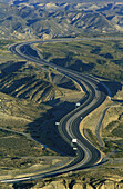 The A 92 motorway from Granada to Almería cuts through the dramatic landscape of bare, eroded sandstone of the Tabernas Desert, Europe s only true desert. Province of Almería, Andalucía, Spain.