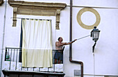 Man cleaning street lamp. Palermo. Sicily. Italy