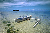 Tropical beach and double trigger canoe. Moorea. Tahiti. French Polynesia