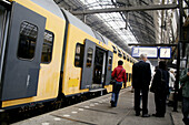 Passengers and train in Amsterdam central station, Amsterdam, Holland, Netherlands
