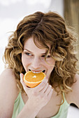 s, Aliment, Aliments, Bite, Bites, Biting, Caucasian, Caucasians, Citrus fruits, Close up, Close-up, Closeup, Color, Colour, Curly hair, Daytime, Delicious, Exterior, Female, Food, Foodstuff, Fruit, F