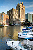 100 East Wisconsin Building and downtown from riverwalk of Milwaukee River in afternoon. Milwaukee. Wisconsin, USA