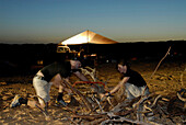 Man sawing wood, Camping in the desert, Offroad 4x4 Sahara Desert Tour, Bebel Tembain area, Sahara, Tunisia, Africa, mr