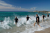 Eine Gruppe von Männer laufen ins Meer, Abenteuer Wettbewerb, in der Nähe von Rena Majore, Sardegna, Sardinien, Italien, Europa