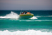 People in a speedboat shipping along Sandy Bay coastline, Cape Town, South Africa