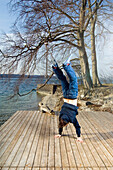 Man performing handstand, Starnberg Lake, Starnberg, Bavaria, Germany