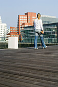 Woman walking through Media Harbor, Dusseldorf, North Rhine-Westphalia, Germany