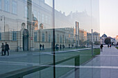 Passanten und Gebäude spiegeln sich in Glasfront, Museumsquartier, Wien, Österreich