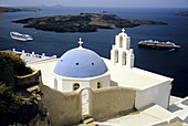 Dome and bell tower of Kimis Theotokov Greek Orthodox church at Thíra with cruise chips anchored below. Santorini, Cyclades Islands. Greece