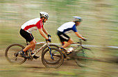 Mountain biker riding fast in forest at Deer Valley. Utah, USA