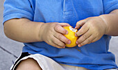 Toddler peeling tangerine