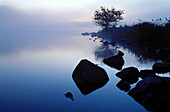 Lake in morning mist with rocks