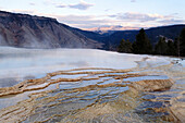 Yellowstone NP, USA - Geyser and terrace and mountains