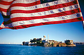 American flag and Alcatraz Island in background. San Francisco. California. USA