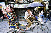 Young man playing a flute on rickshaw. Kathmandu. Nepal