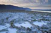 Black Mountains and flooded salt pan at sunrise, Devils Golf Course, Middle Basin, Death Valley, California