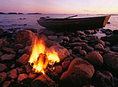 Campfire at shore and boat. Västerbotten. Sweden