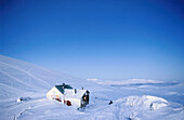 An enlightened cabin in the mountains. In blue evening light. Lapland. Sweden.