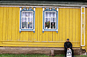 A yellow house with two windows and a boy waiting for the bus. Near Ufa. Bashkortostan. Russia.