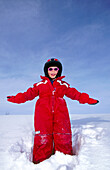 A happy 4 years old girl with a ski helmet, arms outstretched. Skorvfjallet. Västerbotten, Sweden