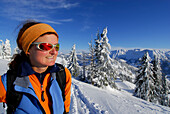 Junge Frau im Aufstieg durch tief verschneiten Winterwald zum Spieser, Allgäuer Alpen, Allgäu, Schwaben, Bayern, Deutschland