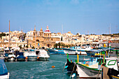 Boats at harbour in front of the church of Marsaxlokk, Malta, Europe