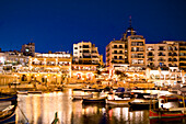 Boote in einer Bucht vor beleuchteten Häusern, Spinola Bay, St. Julian´s, Malta, Europa