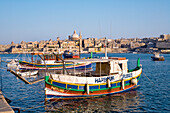 Buntes Ausflugsschiff im Marsamxett Hafen mit Blick auf die Stadt Valletta, Sliema, Malta, Europa