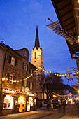Weihnachtliche Ludwigstraße mit Kirche Maria Himmelfahrt, Garmisch-Partenkrichen, Bayern, Deutschland